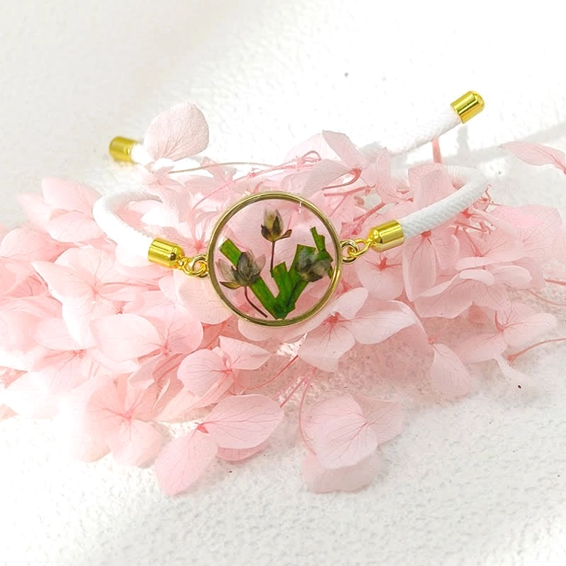 White braided rope birth flower bracelet with green leafy pressed flower resin charm