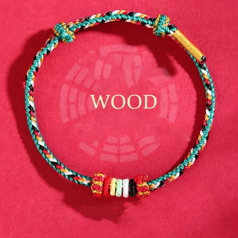 Wood element teal braided rope bracelet with red and colorful spacer beads and decorative knots on red bagua background