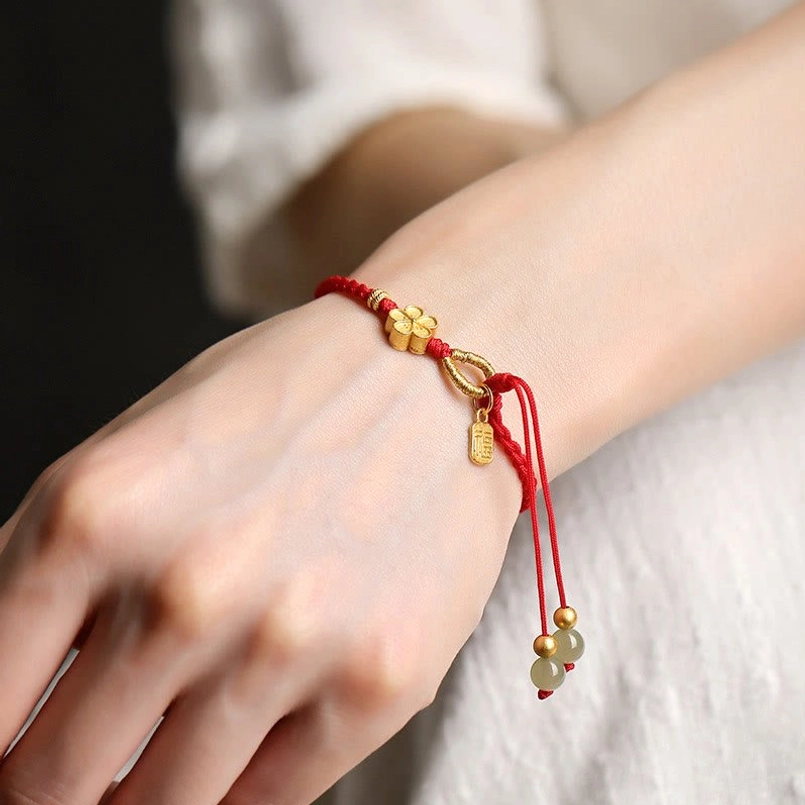 Hetian jade red string bracelet worn on human wrist close up shot