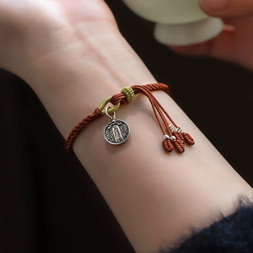 Side view of five wealth gods red string bracelet worn on human wrist