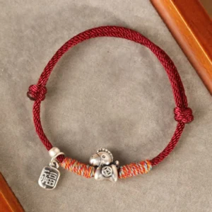 Year of the Horse Fu character sterling silver red string bracelet handcrafted top-down flat lay on velvet with wooden frame