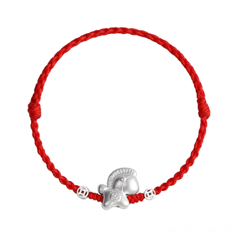 Flat lay of Year of the Horse red string bracelets with sterling silver charms on burgundy fabric background