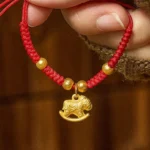 Year of the Horse red string copper bracelet with flat rocking horse charm and gold beads, adjustable knitted cord
