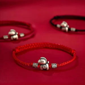 Year of the Horse 999 sterling silver red string protection bracelet set on dark red background