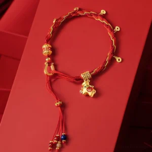 Year of the Horse Fu red string bracelet with 18k gold plated charm displayed on red background, showing intricate beadwork and horse pendant