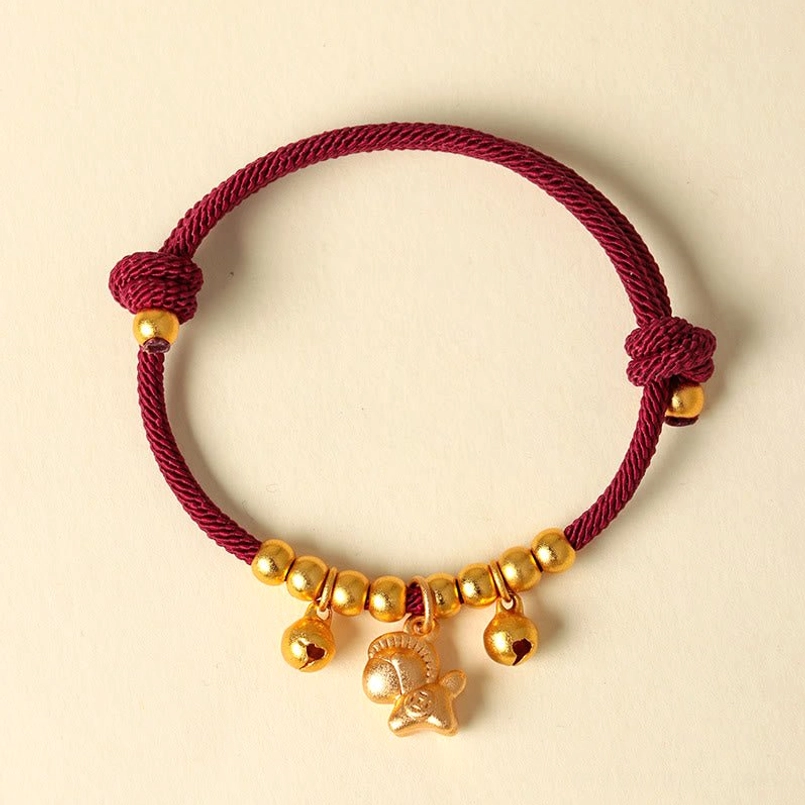 Chinese zodiac horse lucky bracelet red cord with gold beads bells and horse pendant on beige background