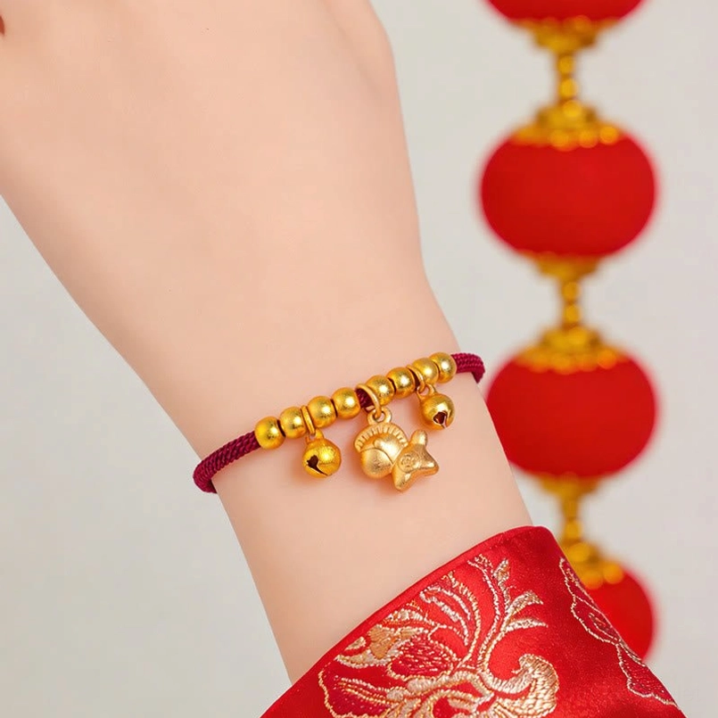 Lucky horse zodiac bracelet worn on female wrist with gold horse pendant bells red lantern background