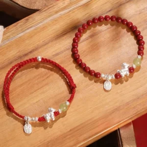 Year of the Horse red string beaded bracelet flat lay on wooden tabletop