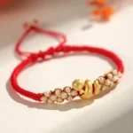 Year of the Snake red string bracelet top close up view with 999 sterling silver charm