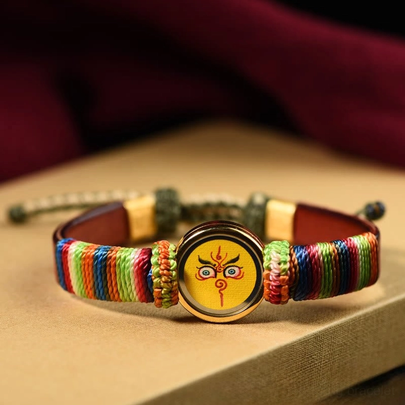 Yellow Jambhala Buddha eye blessing bracelet with rainbow woven rope and gold frame