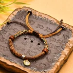 Yellow Tibetan braided Zakiram goddess of wealth red string bracelet on vintage stone tray