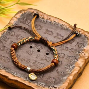 Yellow Tibetan braided Zakiram goddess of wealth red string bracelet on vintage stone tray