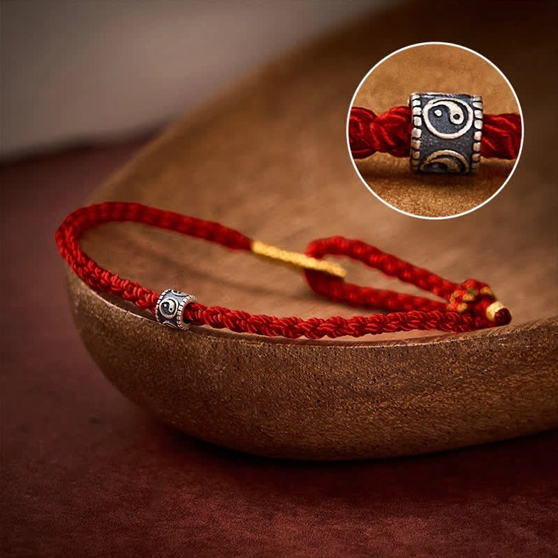 Close-up of sterling silver Yin Yang bead on hand-knotted red cord bracelet