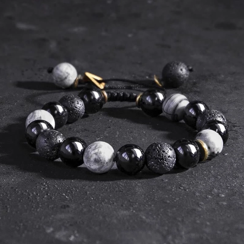 Yin Yang beaded bracelet flat lay top down view on dark smooth stone background