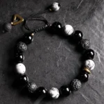 Yin Yang black obsidian lava rock bracelet oblique top view on dark stone table