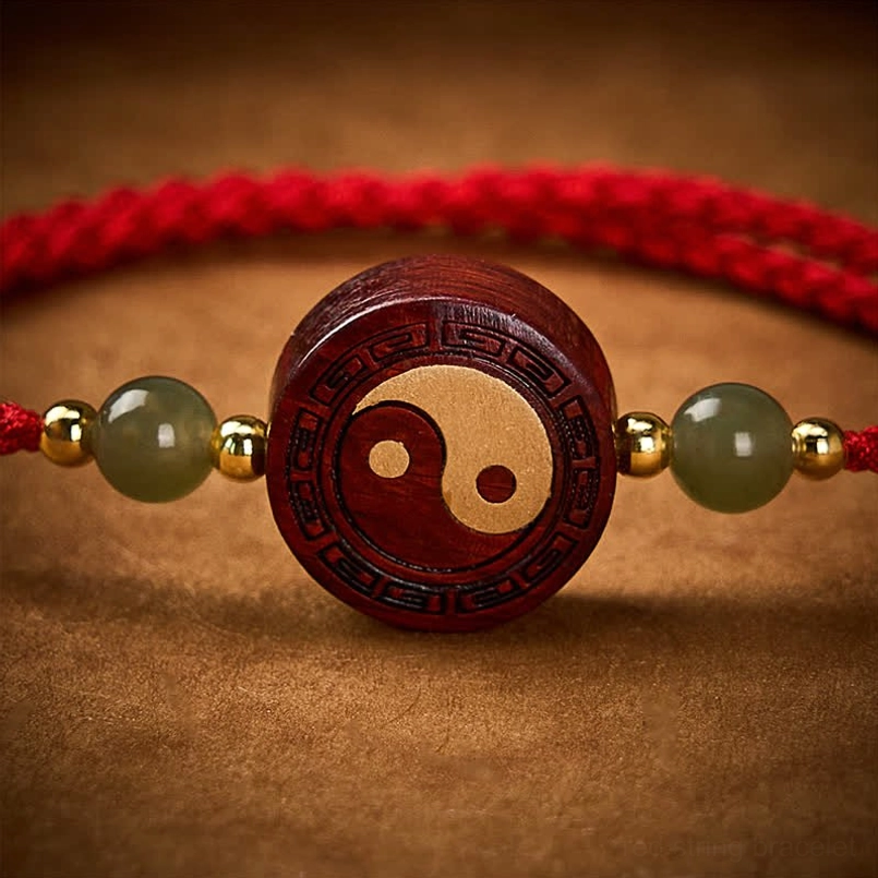 Extreme close-up of engraved wooden charm on red string bracelet
