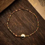 Hand-woven Yin Yang red string protection bracelet with colorful braided cord and gold-rimmed tai chi charm
