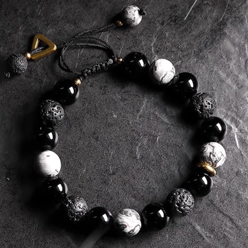 Adjustable yin yang beaded bracelet with black obsidian and lava rock stones, flat lay top view