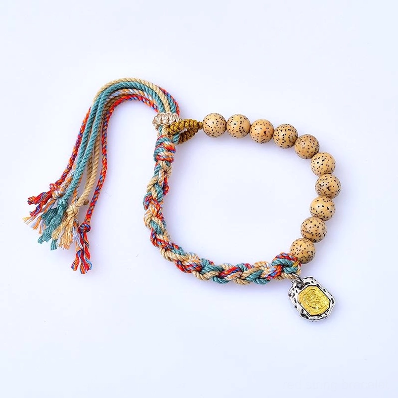 Red string Bodhi seed protection bracelet with metal pendant on white background