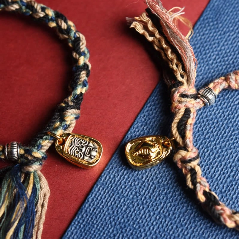 Two handmade Zakiram goddess bracelets showing color variants with matching metal charms and tassels