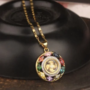 Colorful zircon rotating copper pendant necklace with gold chain on black ceramic surface