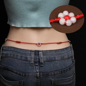 Chinese zodiac red string belly chain worn on waist with denim outfit - peach wood jade charm visible