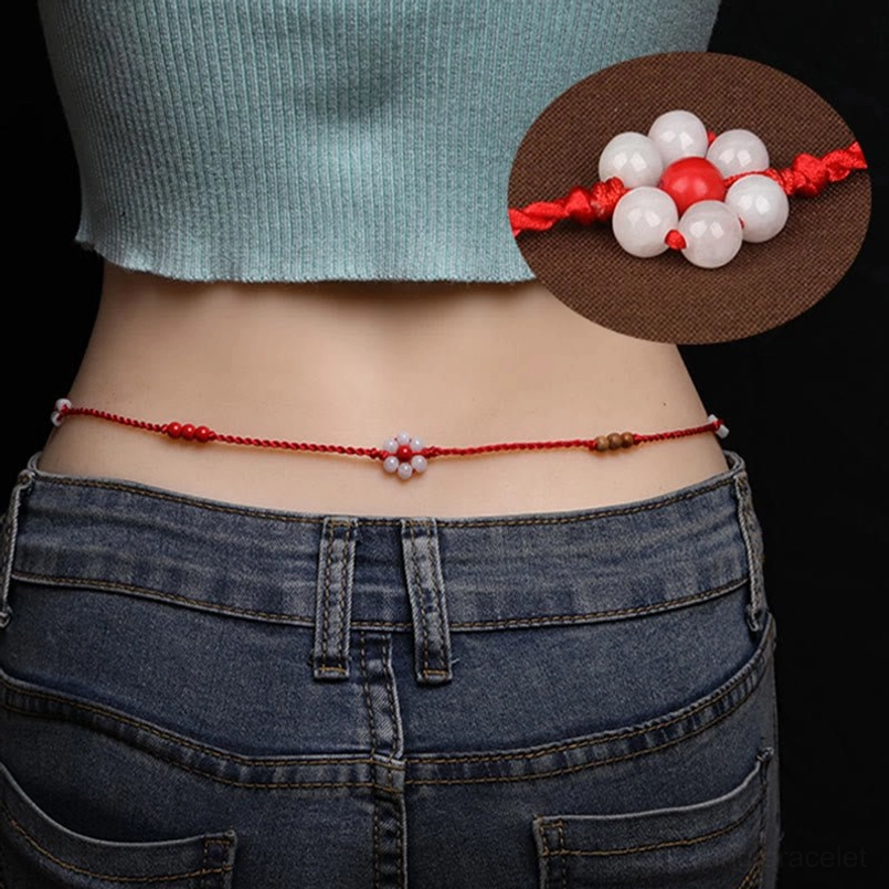 Chinese zodiac red string belly chain worn on waist with denim outfit - peach wood jade charm visible