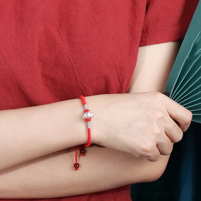 Adjustable red braided rope zodiac bracelet front view worn with silver charm and red bead tassel