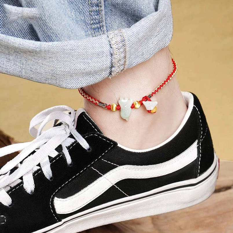 Zodiac jade red string anklet close-up with white jade charm and gold accents