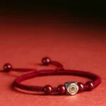 Chinese zodiac natal buddha red string bracelet with cinnabar beads and 925 sterling silver guardian bead on gradient background