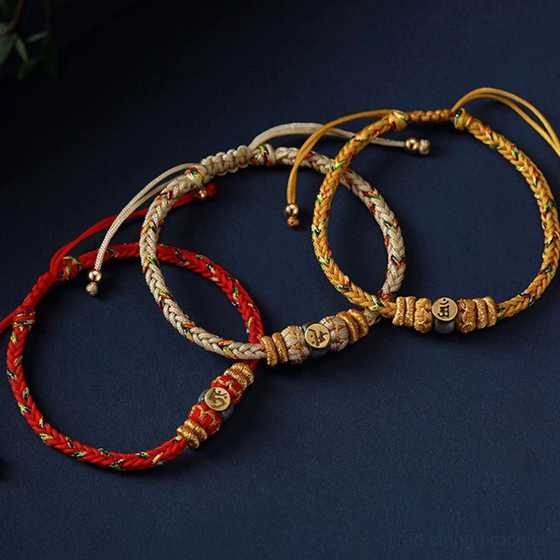 Multiple zodiac natal buddha bracelets in red, beige and gold colors with woven ropes and assorted charm bead designs