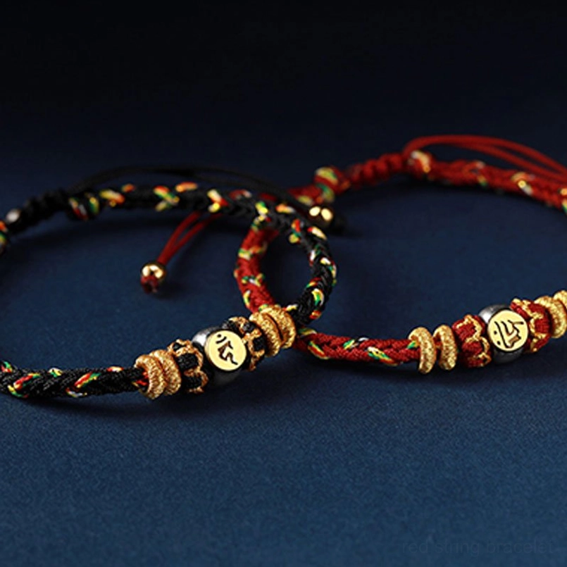 Pair of zodiac natal buddha charm bracelets with black and red woven cords and engraved gold metal beads detail