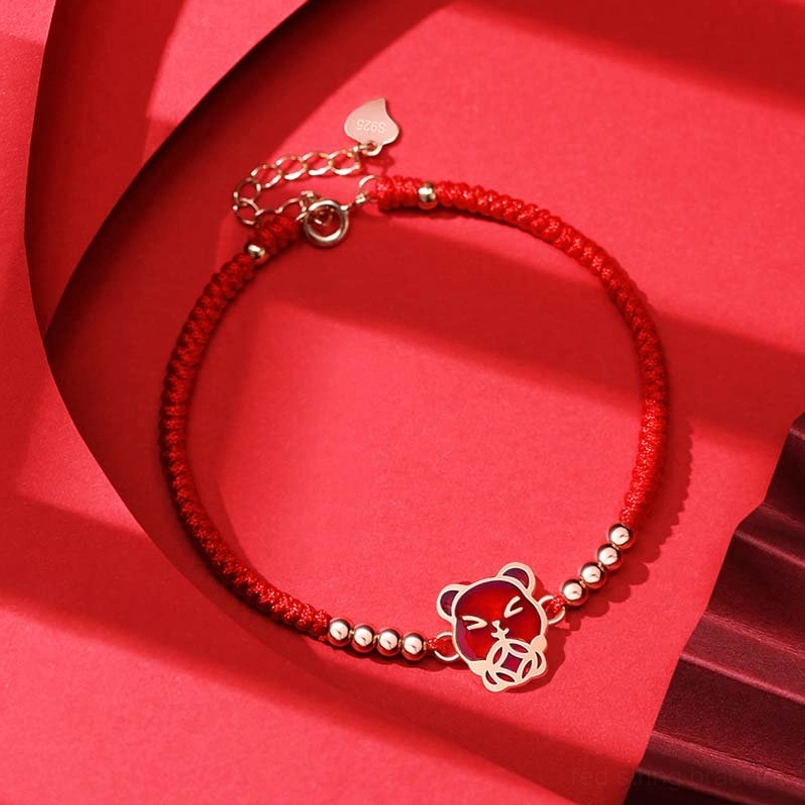 Chinese zodiac pig red string bracelet with rose gold charm on red fabric
