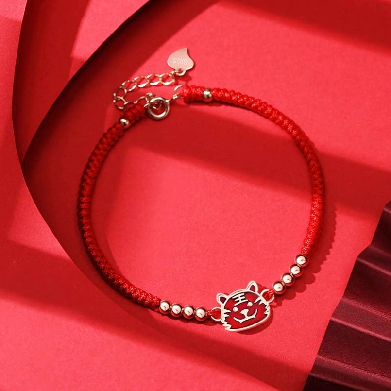 Chinese zodiac tiger red string bracelet with enamel charm flat lay