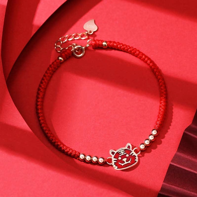 Chinese Zodiac Tiger red string bracelet with enamel tiger charm and gold beads flat lay
