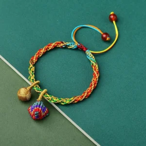 Colorful five element zongzi charm bracelet with multicolor braided rope and pendants on dark green background